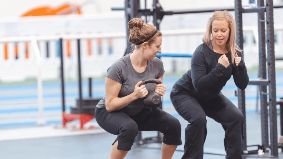 Gym beginner works out with coach