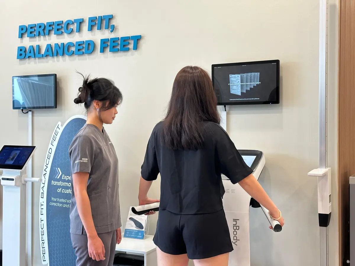 Physiotherapist assisting a patient in doing an InBody test