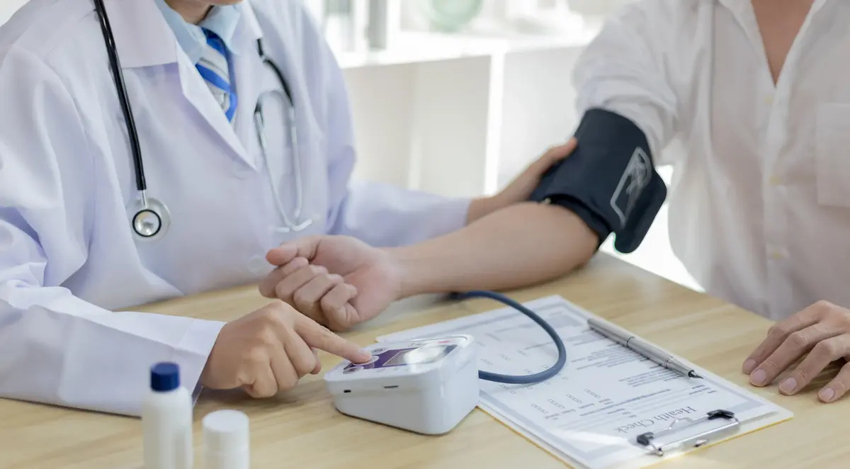 Doctor measuring a patient’s blood pressure with a blood pressure monitor 