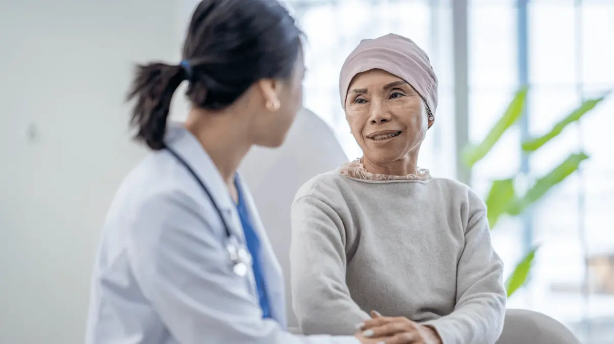 Female doctor reassuring her cancer patient in her hospital ward